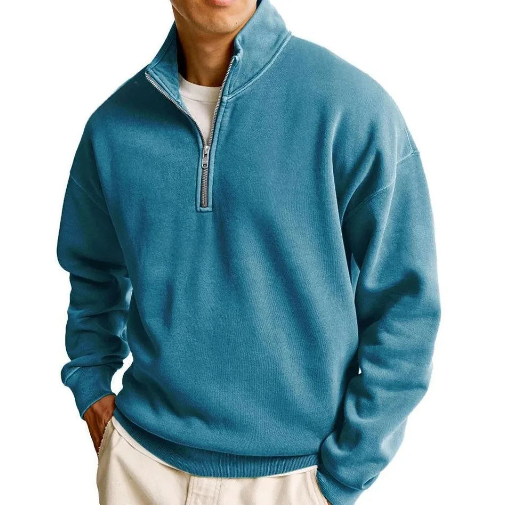 Man wearing a blue quarter-zip pullover on a white background