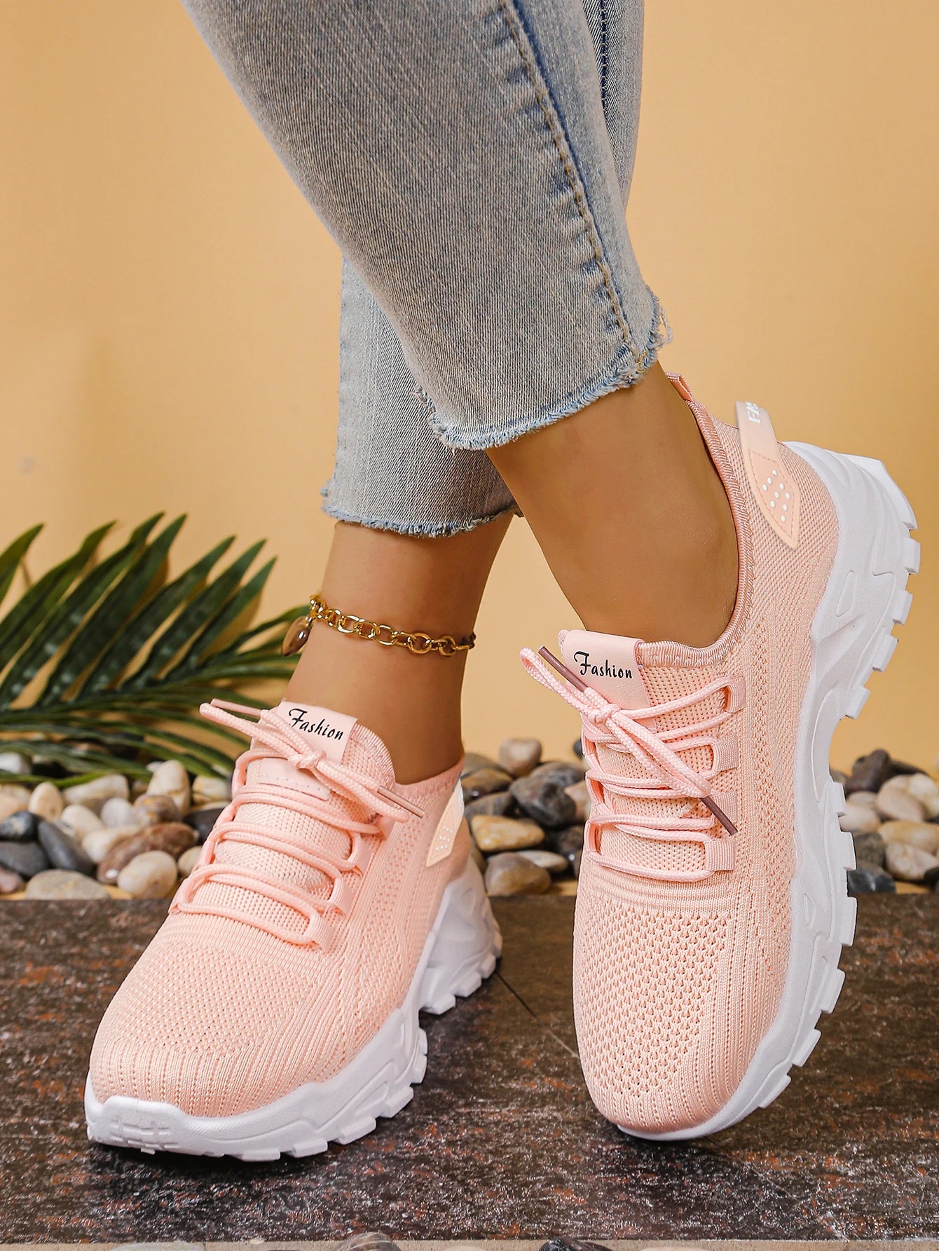 Pink sneakers worn with light Blue jeans on a natural background