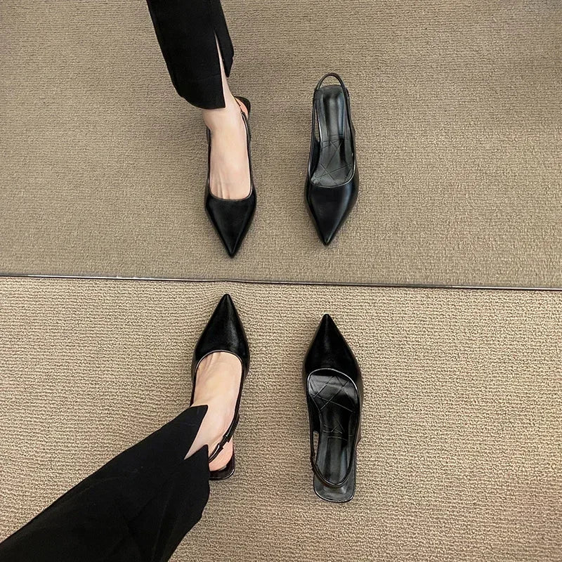 Black high-heeled shoes on a beige carpet