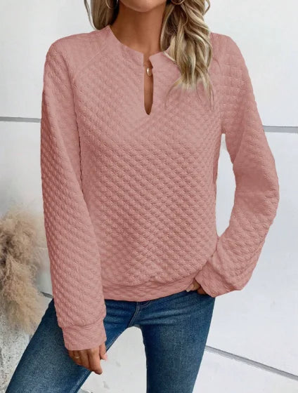 Person wearing a Pink textuRed sweater and Blue jeans against a White background