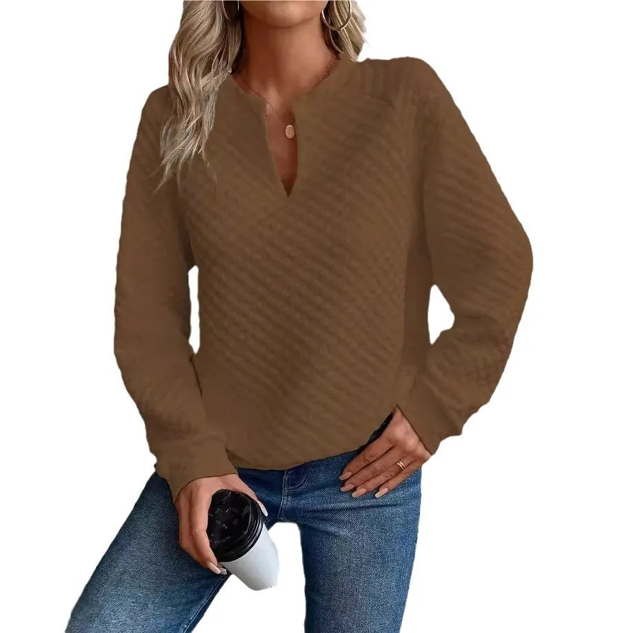 Woman wearing a Brown long-sleeve top and Blue jeans, holding a coffee cup on a White background