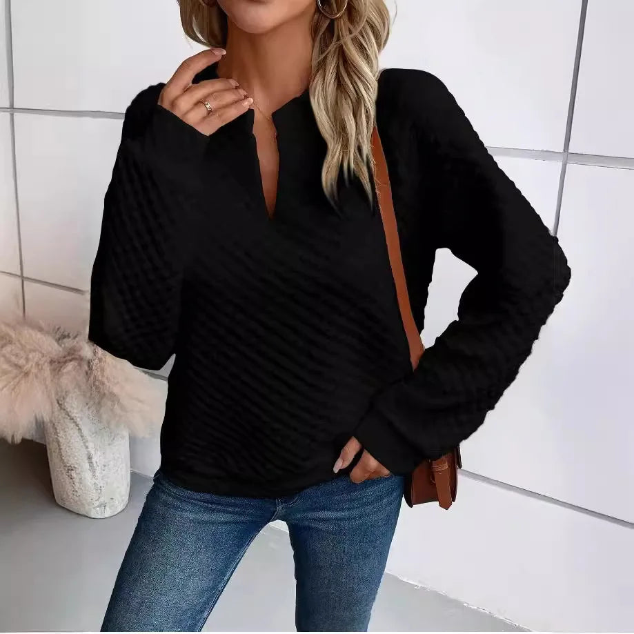 Person wearing a Black sweater and Blue jeans with a White tiled wall background