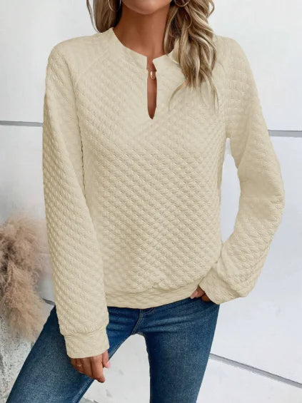 Person wearing a textuRed beige sweater and Blue jeans against a White background