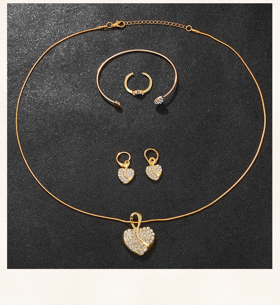 Gold jewelry set with necklace, earrings, and ring on a dark background