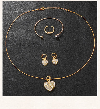 Gold jewelry set with necklace, earrings, and ring on a dark background