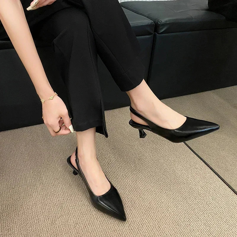Person wearing Black high-heeled shoes sitting on a couch.
