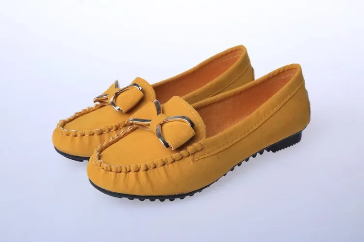 Pair of yellow loafers on a light Gray background