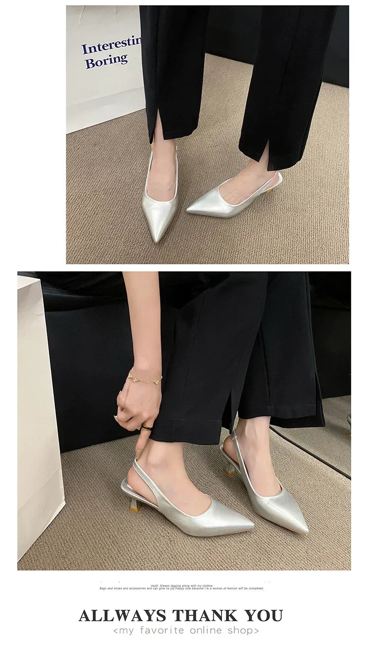 Silver pointed-toe shoes worn with Black pants on a neutral background.