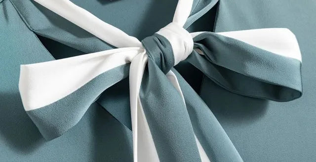 Close-up of a teal fabric with a White bow on a matching teal background