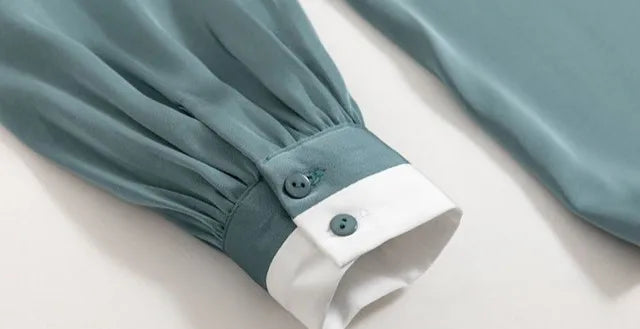 Teal sleeve with White cuff on a light Gray background