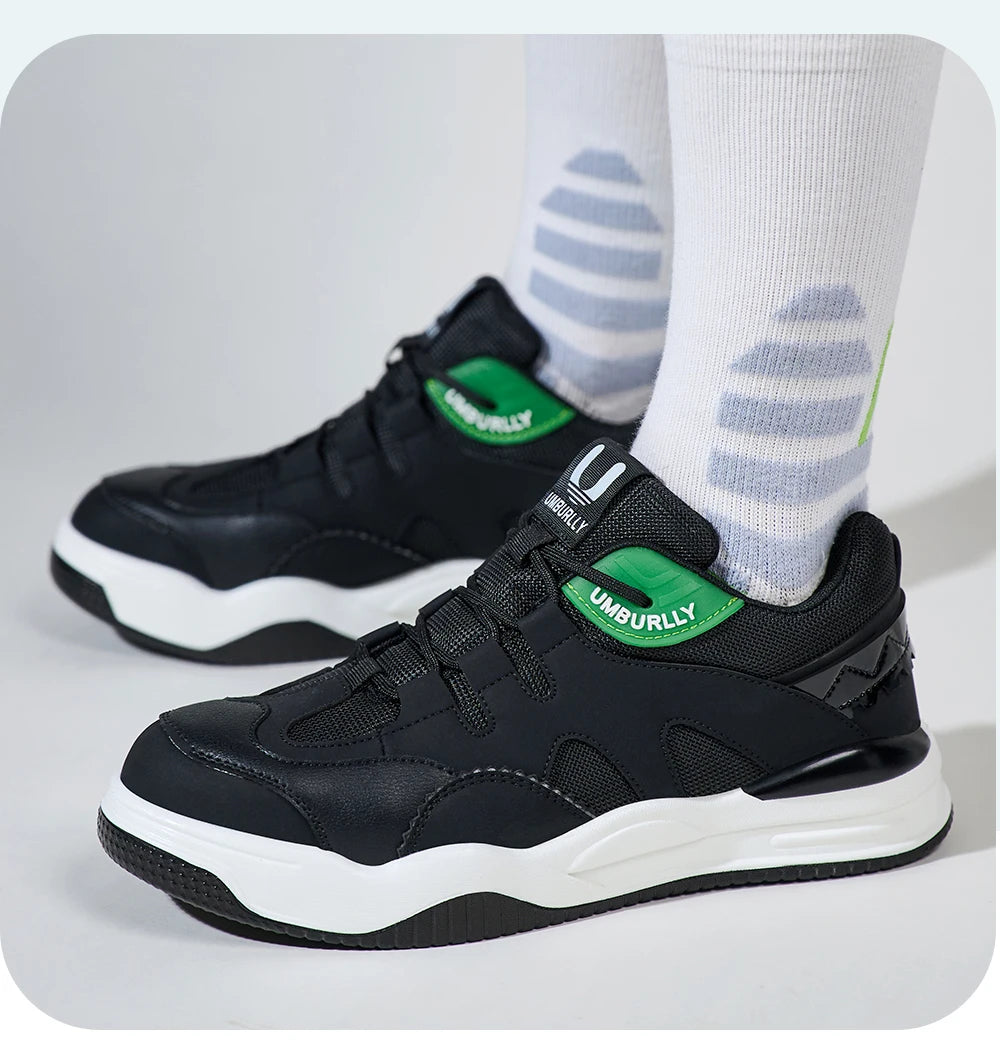 Black sneakers with Green accents worn with White socks on a light Gray background