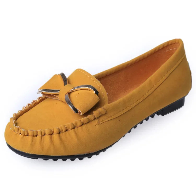 Yellow loafer shoe with a decorative buckle on a White background