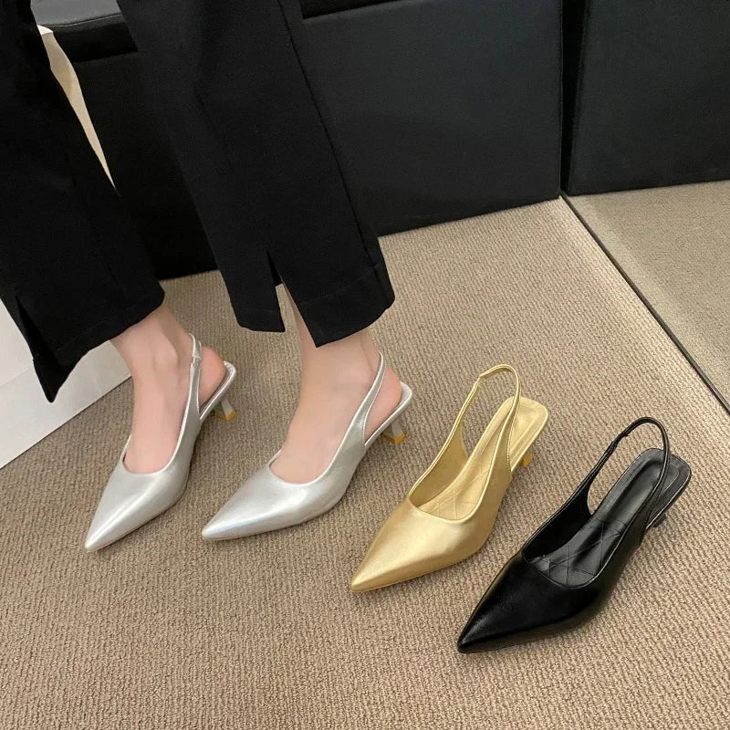 Three pairs of pointed-toe slingback heels in silver, gold, and Black on a carpeted floor.