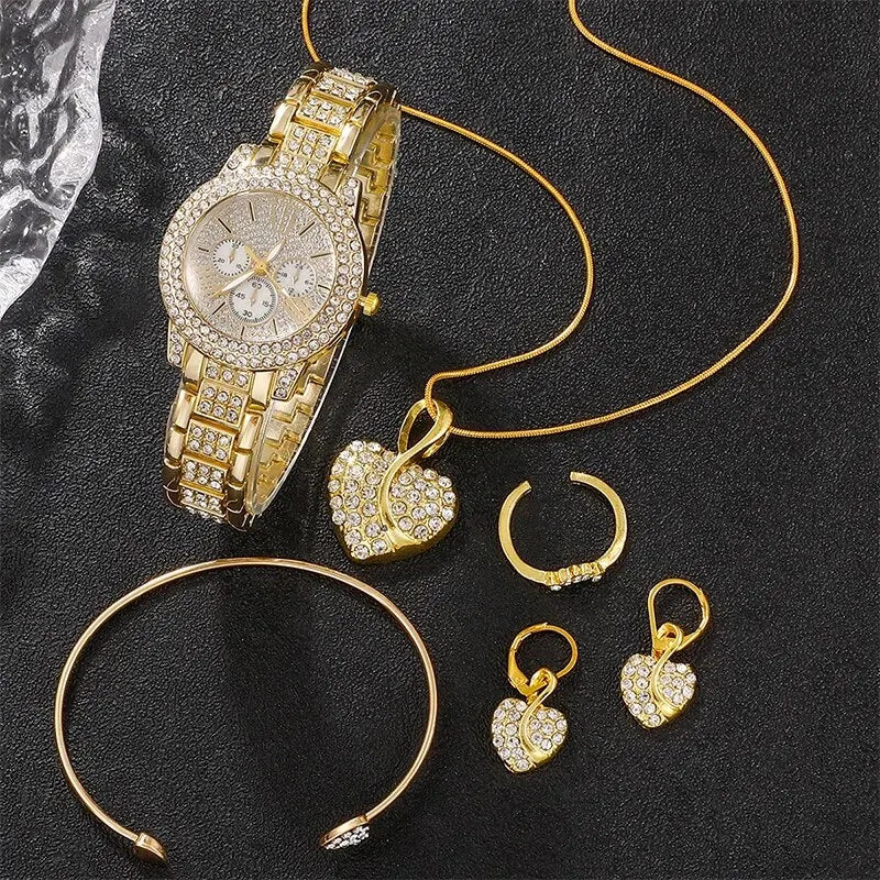 Gold jewelry including a watch, necklace, earrings, and headband on a dark surface.