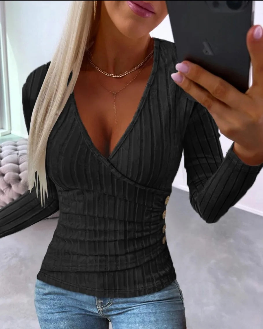 Woman wearing a Black ribbed top and Blue jeans, taking a mirror selfie.