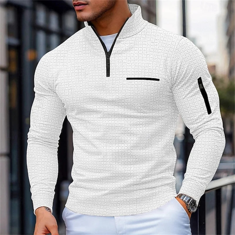 Man wearing a White textuRed sweater with Black accents in an urban setting