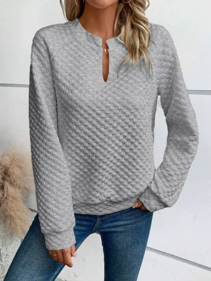 Person wearing a textuRed Gray sweater and Blue jeans against a White background