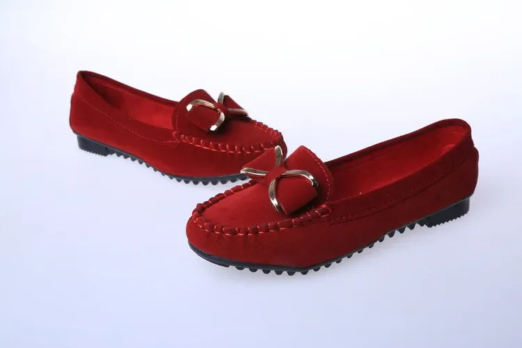 Pair of Red loafers with metal buckles on a White background