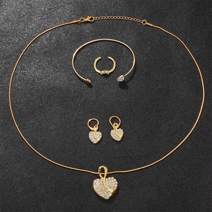 Gold jewelry set including necklace, bracelet, and earrings on a dark surface