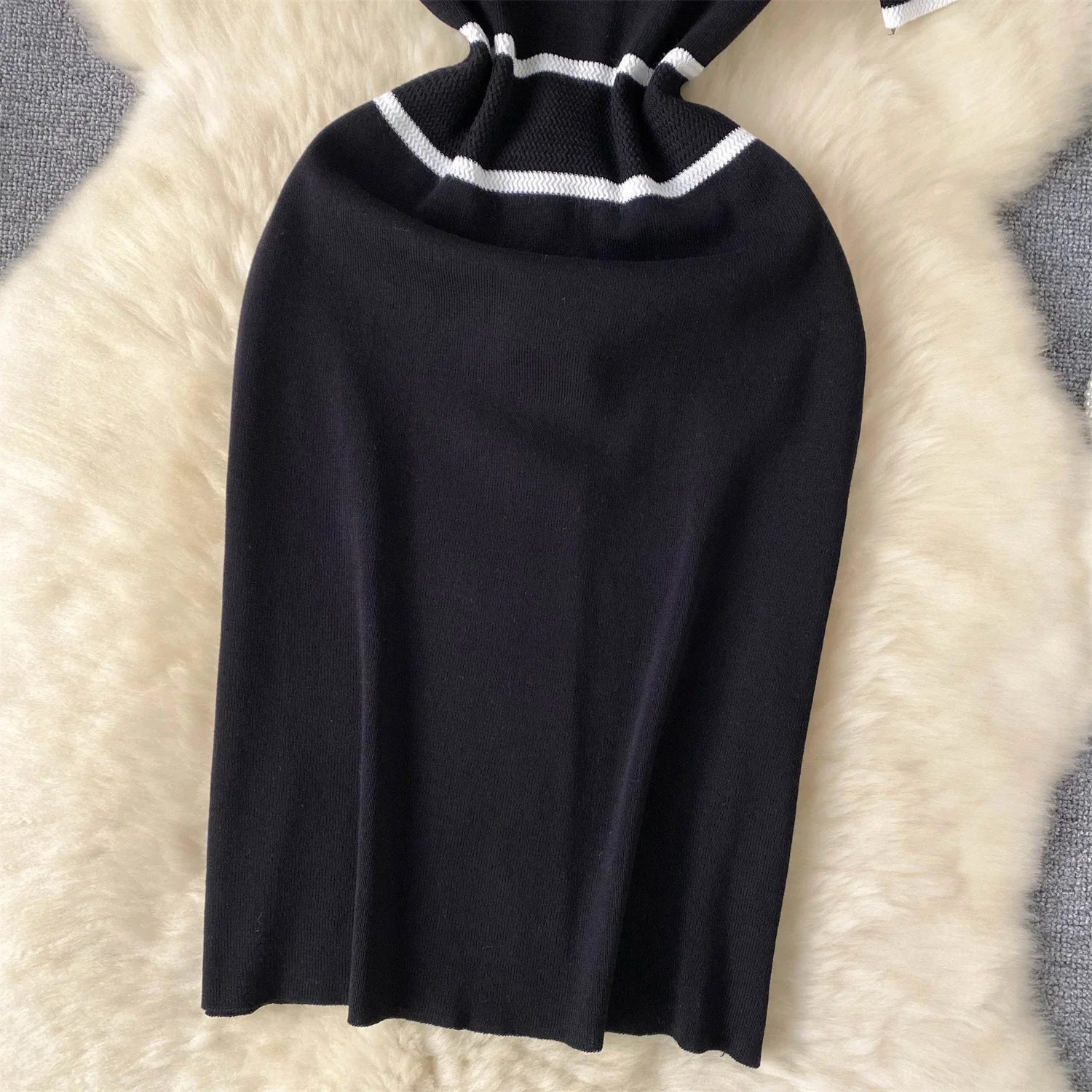 Black knit skirt with White trim on a textuRed surface