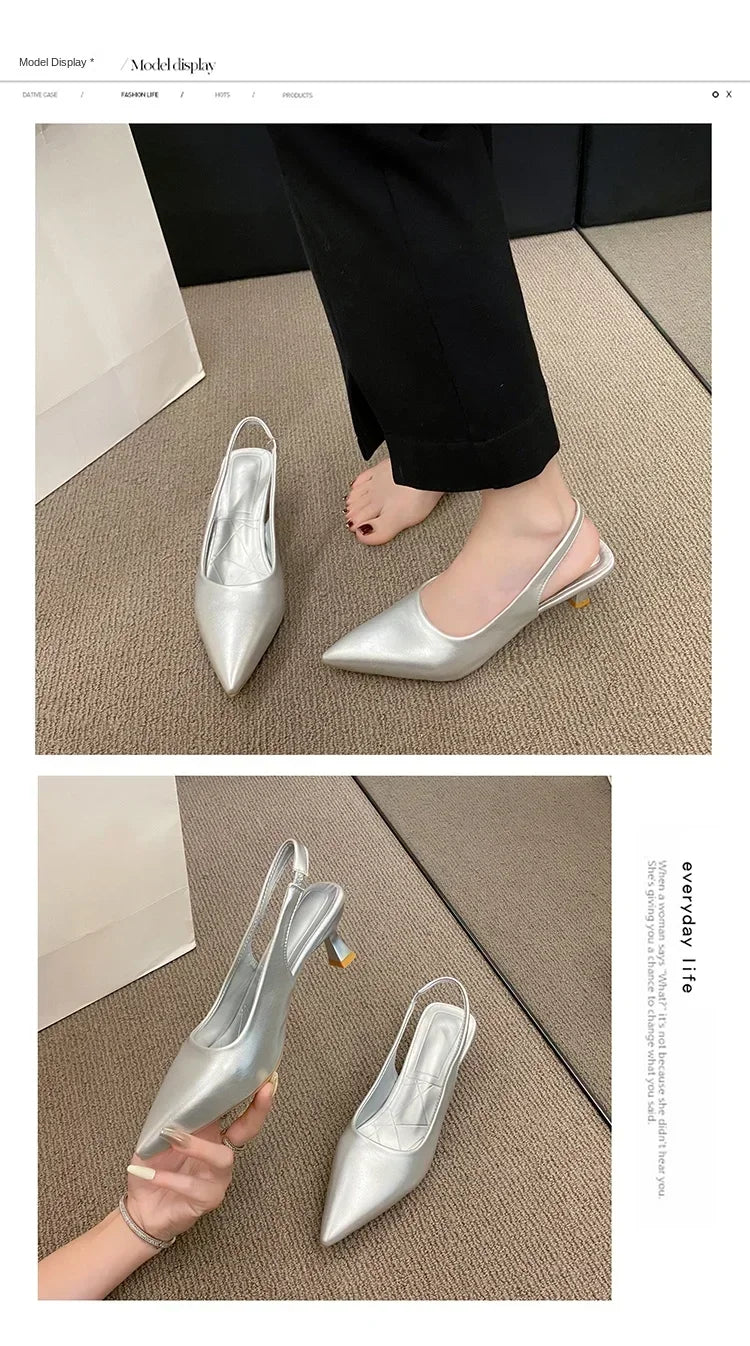 Silver high-heeled shoes on a beige carpet with a person wearing Black pants.