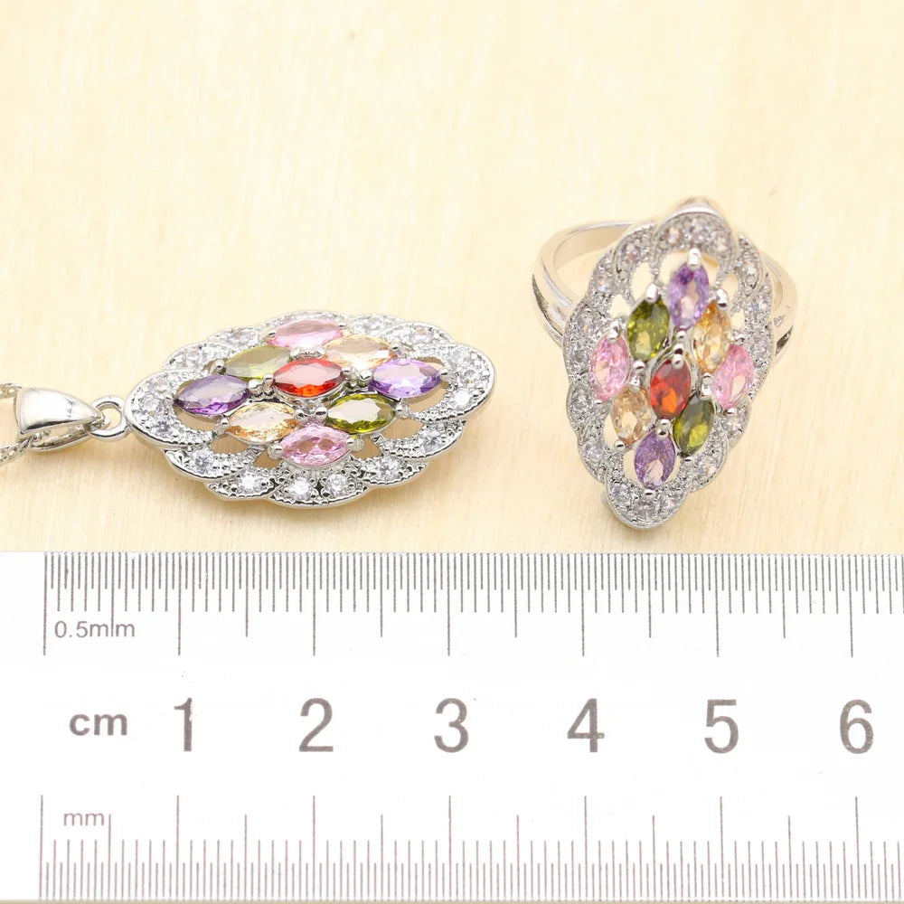MulticoloRed gemstone pendant and ring with a ruler for scale on a beige background