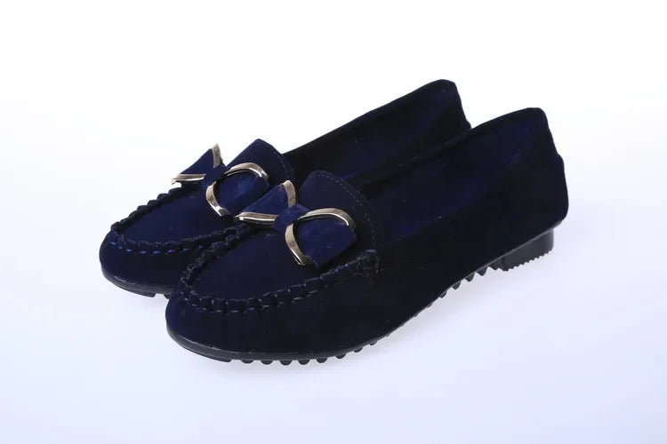 Pair of navy loafers with decorative buckles on a White background