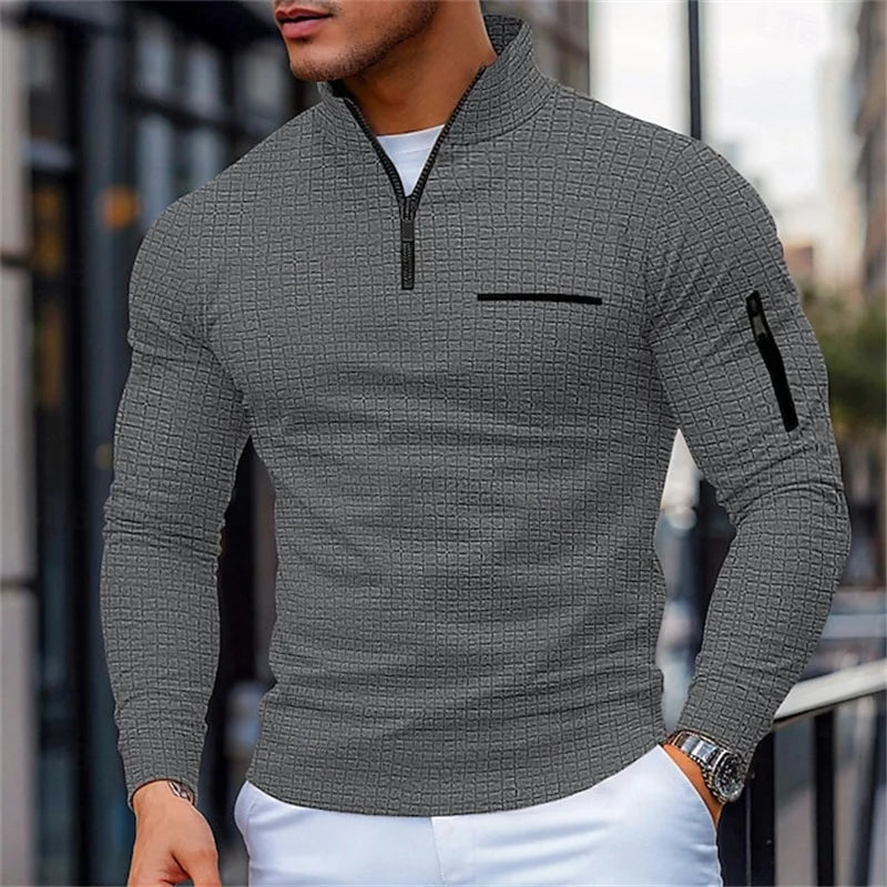 Man wearing a Gray textuRed sweater with a zipper and Black accents in an urban setting.