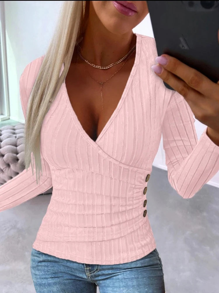Woman wearing a Pink ribbed sweater with button details, standing in front of a mirror.