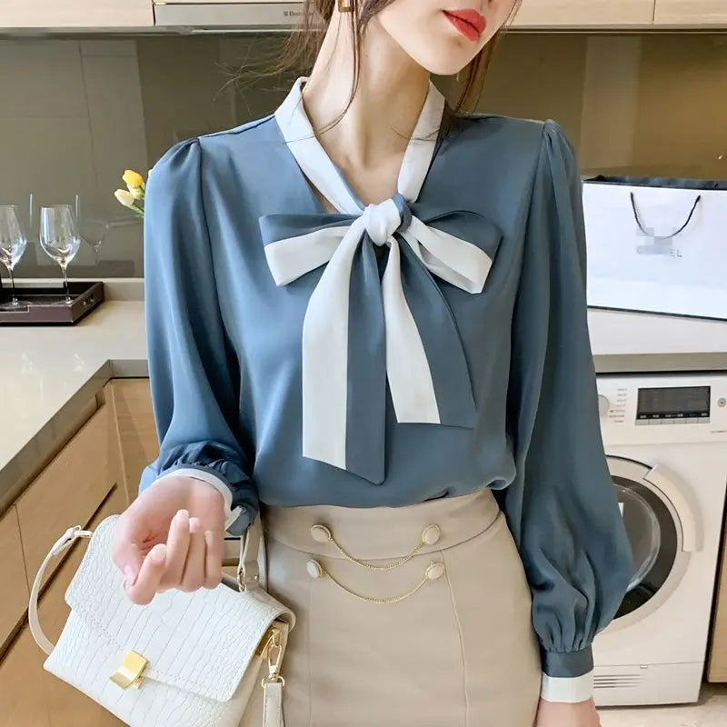 Woman wearing a Blue blouse with a White bow in a kitchen setting