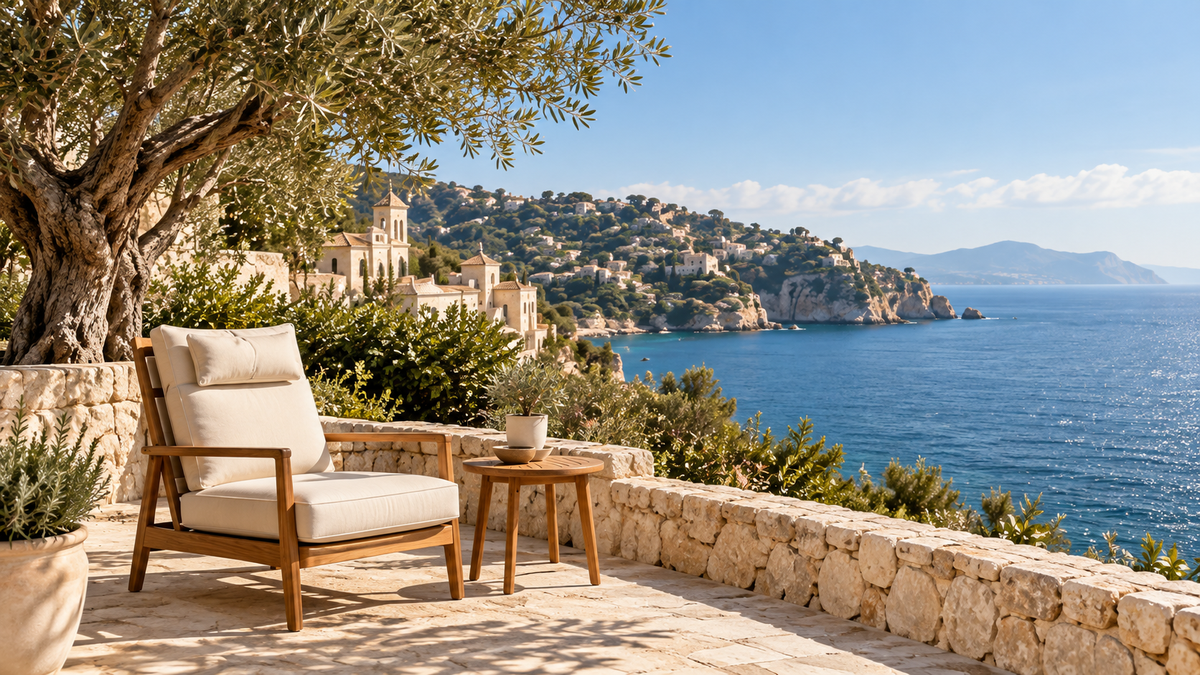 Mediterranean coastal terrace with an olive tree and cream lounge chair