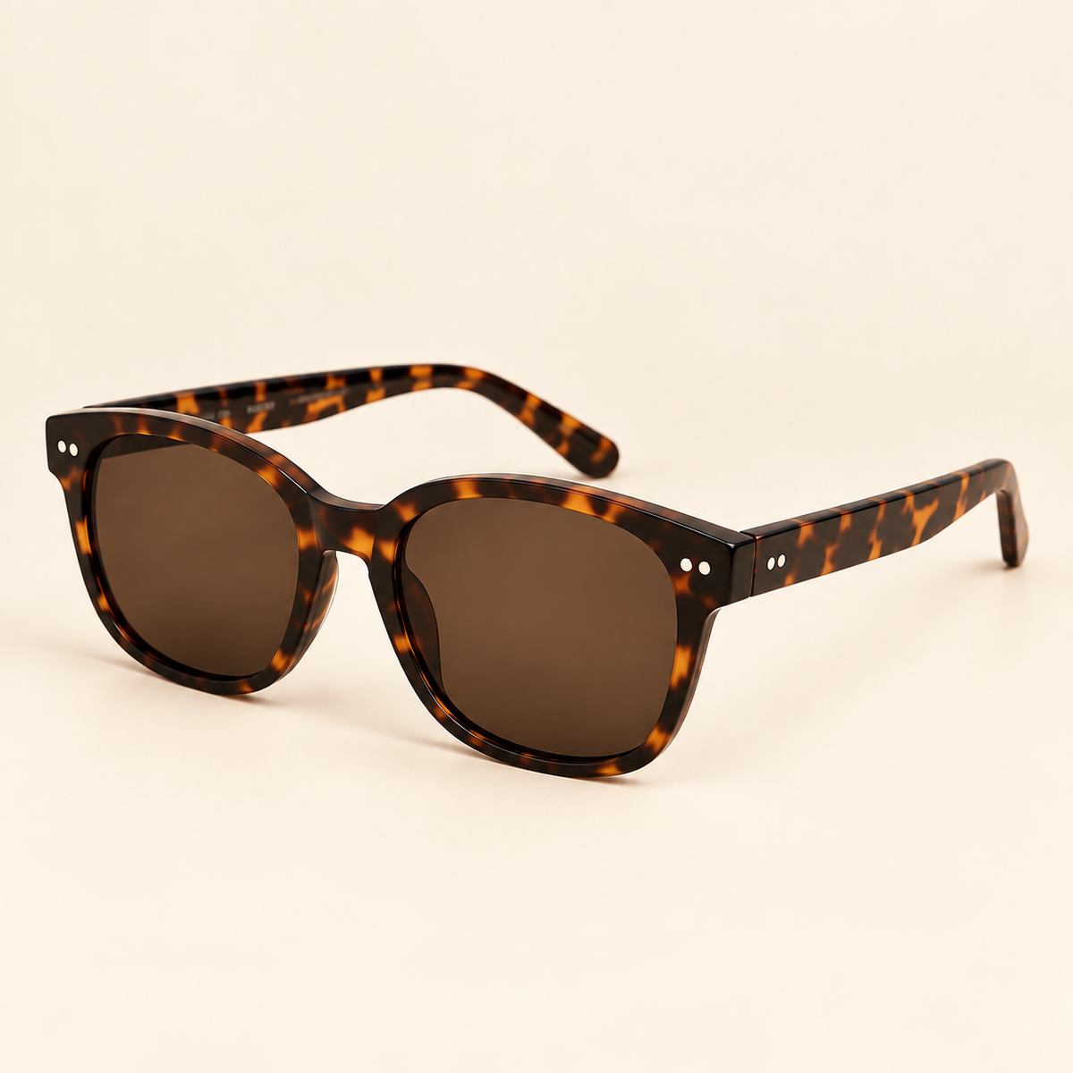 Vintage tortoiseshell sunglasses three-quarter view on warm cream background