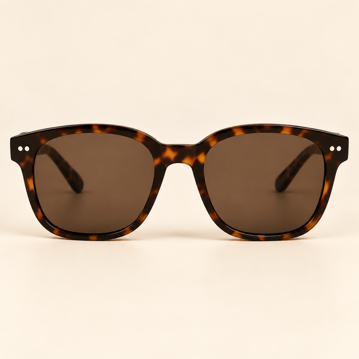 Vintage tortoiseshell sunglasses straight front view on warm cream background