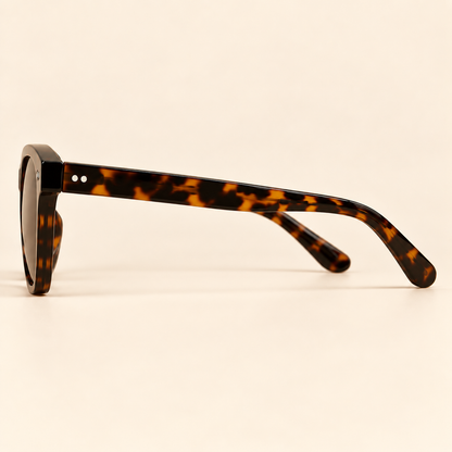 Vintage tortoiseshell sunglasses side profile on warm cream background
